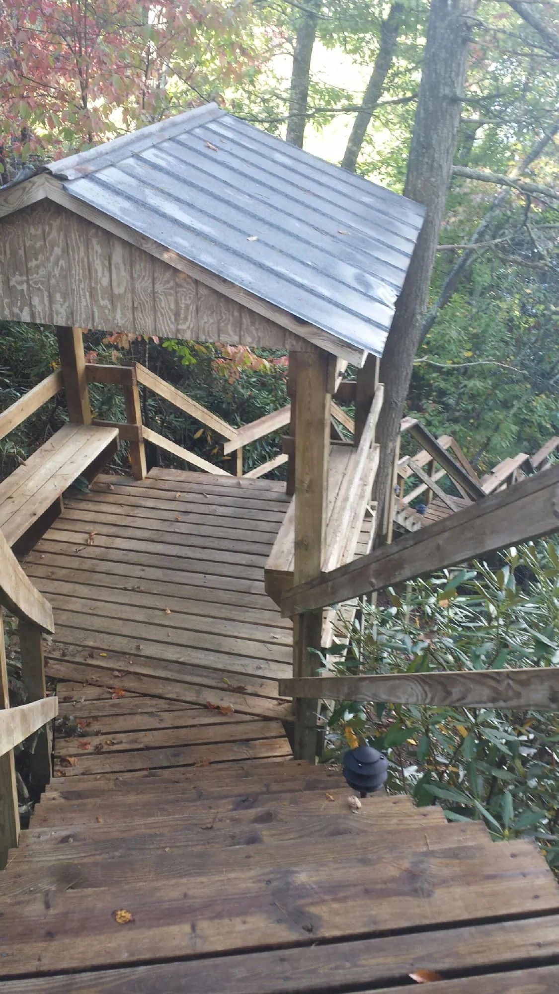 Metal roofed shelter over wooden steps on a wooded walkway — Skylight Repair & Installation work by our crew in Freeport